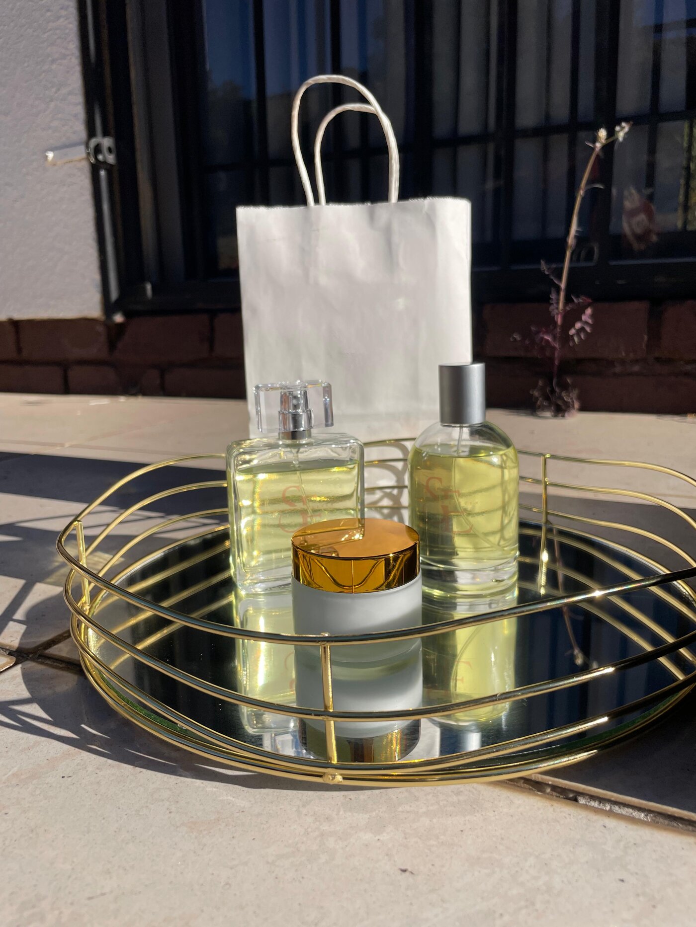 The YouNique Collection perfume bottles by Scents Eleven, presented on a mirrored gold tray